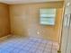Modest bedroom featuring tile floors, window providing natural light and simple, neutral walls at 4394 Prince Hall Blvd, Orlando, FL 32811