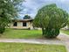 Cozy home featuring an inviting front yard with green grass and landscaping at 4394 Prince Hall Blvd, Orlando, FL 32811