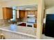 A view of a kitchen with wooden cabinets, tile countertops, and a black refrigerator at 4394 Prince Hall Blvd, Orlando, FL 32811