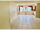 Large open living space with neutral tile floors and a vintage chandelier at 4394 Prince Hall Blvd, Orlando, FL 32811