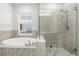Bright bathroom with a glass shower, soaking tub, and tiled walls at 4509 Belkin Ct, Orlando, FL 32814
