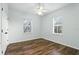 Bedroom featuring wood floors, a ceiling fan, and two large windows at 4509 Belkin Ct, Orlando, FL 32814