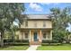 Charming two-story home with a metal roof, covered porch, manicured landscaping, and a welcoming blue front door at 4509 Belkin Ct, Orlando, FL 32814