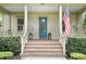 Inviting front porch with brick steps, a blue front door, and charming decor with an American flag waving proudly at 4509 Belkin Ct, Orlando, FL 32814