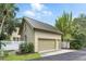 A detached two-car garage featuring durable metal roofing, side service door, and neutral siding complementing the home's architecture at 4509 Belkin Ct, Orlando, FL 32814