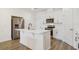 Modern kitchen featuring white cabinetry, stainless steel appliances, and a center island with stylish sink and faucet at 452 Diamond Dove Cv, Winter Springs, FL 32708