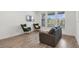 Modern living room with hardwood floors, large windows, comfortable seating, and a wall-mounted TV at 452 Diamond Dove Cv, Winter Springs, FL 32708