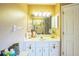 Bright bathroom featuring a vanity with sink, a mirror with lights, and a white door at 4633 Sw 103Rd Pl, Ocala, FL 34476