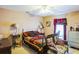 A bright bedroom featuring a colorful quilt, bedside tables with lamps, and a window with decorative curtains at 4633 Sw 103Rd Pl, Ocala, FL 34476