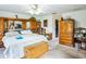 A spacious bedroom featuring light wood built-ins, white walls, and a ceiling fan with lights at 4633 Sw 103Rd Pl, Ocala, FL 34476