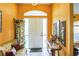Inviting foyer with bright orange walls, a decorative cabinet and table, and a white front door at 4633 Sw 103Rd Pl, Ocala, FL 34476