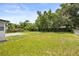 Large grassy backyard with lush trees, a concrete pad, and a serene, natural landscape at 4714 Abaca St, Orlando, FL 32808