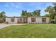 Charming single-story home with white exterior, front lawn, and a welcoming front porch at 4714 Abaca St, Orlando, FL 32808