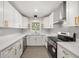 Modern kitchen with stainless steel appliances, white cabinets, and a window overlooking the yard at 4714 Abaca St, Orlando, FL 32808