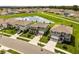 Aerial view of a meticulously landscaped residential neighborhood featuring a pond and well-maintained green spaces at 5226 Mahogany Dr, Mount Dora, FL 32757