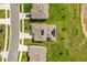 Drone's eye view highlights a green home with solar panels in a well-kept neighborhood next to a pond at 5226 Mahogany Dr, Mount Dora, FL 32757