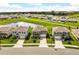 Aerial view of the homes, landscaping and a large pond within a well-maintained residential neighborhood at 5226 Mahogany Dr, Mount Dora, FL 32757