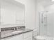Modern bathroom with a granite countertop, a framed mirror, and a glass-enclosed shower at 5226 Mahogany Dr, Mount Dora, FL 32757