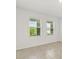 Bright bedroom with two windows providing views of the lush green yard and tile flooring at 5226 Mahogany Dr, Mount Dora, FL 32757