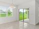 Bright dining room features a modern light fixture, tile flooring, and a sliding glass door to the back yard at 5226 Mahogany Dr, Mount Dora, FL 32757