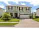 Charming two-story home with a well-manicured lawn and a spacious two-car garage at 5226 Mahogany Dr, Mount Dora, FL 32757