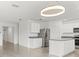 Bright eat-in kitchen features white cabinetry, stainless steel appliances, a kitchen island, and modern light fixture at 5226 Mahogany Dr, Mount Dora, FL 32757