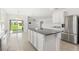 Bright eat-in kitchen features a kitchen island, stainless steel refrigerator, and sliding glass door access at 5226 Mahogany Dr, Mount Dora, FL 32757