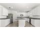 Bright kitchen features white cabinetry, stainless steel appliances, a kitchen island, and tile flooring at 5226 Mahogany Dr, Mount Dora, FL 32757