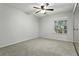 Cozy bedroom with neutral carpet, ceiling fan, and a large window at 5263 Images Cir # 306, Kissimmee, FL 34746