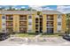 Exterior view of a bright yellow three-story condo building with balconies and ample parking at 5263 Images Cir # 306, Kissimmee, FL 34746