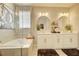 Bright bathroom featuring soaking tub, glass enclosed shower, double sink vanity, and tile flooring at 5310 Teirgarten St, St Cloud, FL 34771