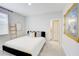 Well-lit bedroom features stylish decor, including a decorative ladder, mirror, and a view to the bathroom at 5310 Teirgarten St, St Cloud, FL 34771