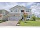 Charming two-story home features a gray exterior, well-maintained landscaping, and a brick driveway at 5310 Teirgarten St, St Cloud, FL 34771