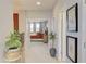 Bright hallway with neutral carpet leads to a bedroom, featuring a potted plant and decorative artwork at 5310 Teirgarten St, St Cloud, FL 34771