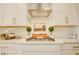 Modern kitchen cooktop with stainless steel range hood and white cabinets at 5310 Teirgarten St, St Cloud, FL 34771