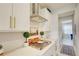 Modern kitchen cooktop with stainless steel range hood and white cabinets at 5310 Teirgarten St, St Cloud, FL 34771