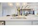 Close-up of a kitchen island with a stainless steel sink, pendant lighting, and countertops at 5310 Teirgarten St, St Cloud, FL 34771