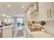 Modern kitchen with white cabinets, gold hardware, stainless steel appliances, and a gas cooktop at 5310 Teirgarten St, St Cloud, FL 34771
