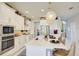Bright, modern kitchen with white cabinets, gold hardware, and a stylish island with pendant lighting at 5310 Teirgarten St, St Cloud, FL 34771