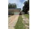 View of the driveway, one car garage, a lawn, and a wooden fence bordering the property at 6308 Stanwin Dr, Apopka, FL 32712