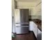 Close-up of an updated kitchen with stainless steel refrigerator, updated countertops, and white cabinets at 6308 Stanwin Dr, Apopka, FL 32712