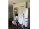Kitchen area with stainless steel refrigerator, closet pantry with louvered doors, and wood-look floors at 6308 Stanwin Dr, Apopka, FL 32712