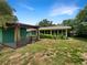 Spacious backyard with a covered patio, green lawn, and mature landscaping at 6740 Odoniel W Loop, Lakeland, FL 33809
