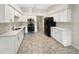 Modern kitchen with white cabinets, stainless appliances, quartz countertops, and tile flooring at 6740 Odoniel W Loop, Lakeland, FL 33809