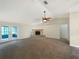 Spacious living room with a brick fireplace, ceiling fan, and access to the patio at 6740 Odoniel W Loop, Lakeland, FL 33809