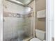 Bathroom featuring a tiled shower with glass door, decorative tile accent, and modern fixtures at 7263 Spring Villas Cir, Orlando, FL 32819
