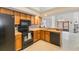 Functional kitchen with wood cabinets, black appliances, and a breakfast bar at 7263 Spring Villas Cir, Orlando, FL 32819
