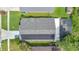 Aerial view of a property with a dark roof, solar panels, enclosed patio and well manicured lawn at 7809 Altavan Ave, Orlando, FL 32822