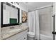 Bathroom featuring granite countertop vanity, tile floors, and shower over tub at 7809 Altavan Ave, Orlando, FL 32822