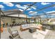 Expansive covered patio with stylish seating, dining area, grill, and a hot tub perfect for outdoor living at 7809 Altavan Ave, Orlando, FL 32822